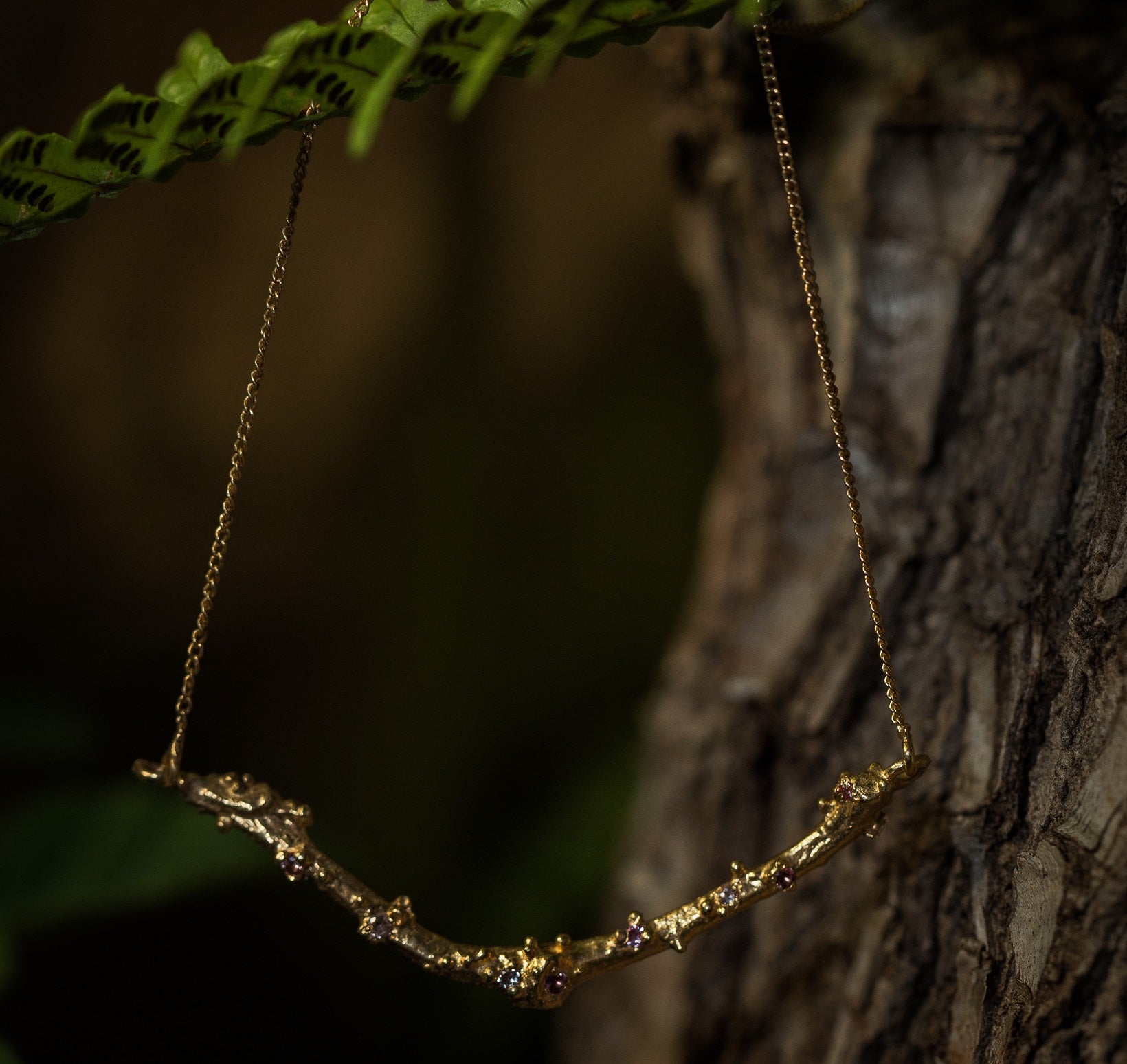 14ct gold twig necklace set with nine colorful Sapphires